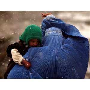 An Afghan Woman Holding Her Child Throws Back Her Burqa to See Her Way 