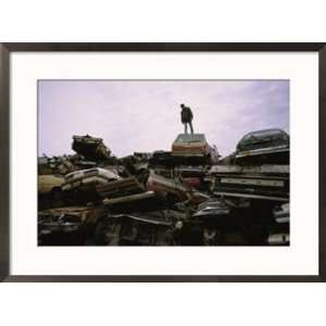  A Man Stands Atop a Pile of Crushed Cars at a Salvage Yard 